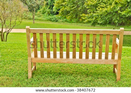 Empty wood bench on grass overlooking a path