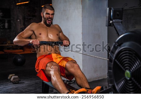 Man running rowing excercise in the gym.