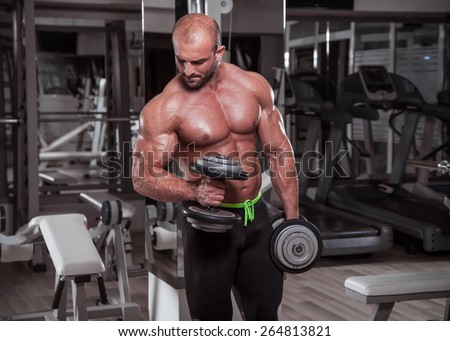 Handsome young athletic men exercise with dumbbells.