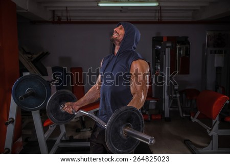 Body builder performing barbell curls exercise.