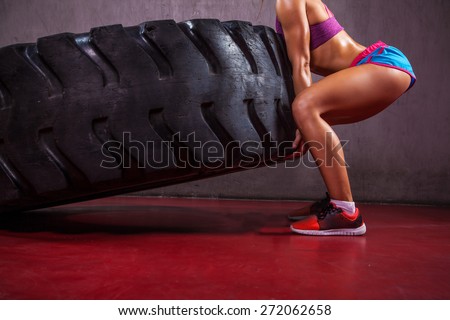 Unknown fit girl flipping big tire.