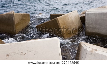 Breakwater with some concrete cubes in the sea.
