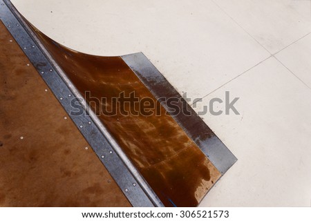 Detail of a wooden and metal quarter pipe ramp with rail in a skate park. Copy-space for placing text.