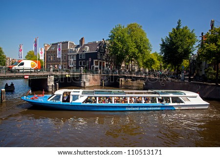 AMSTERDAM, NETHERLANDS - AUG 1: Tourist boat cruises on Prinsengracht in Amsterdam on August 1, 2012. Almost 20 percent of all canal cruise boats are now electrically powered