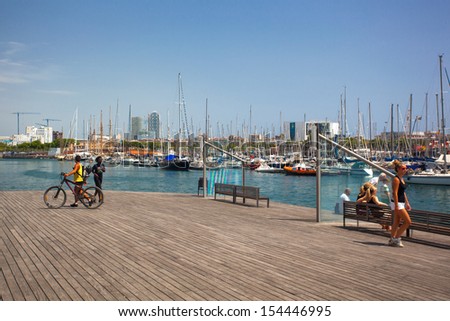 BARCELONA, SPAIN - AUG 5: Tourists on Port Vell on August 5, 2013 in Barcelona, Spain. Number of tourists visiting Barcelona is more than 7 million. It is world\'s 4th most visited tourist destination