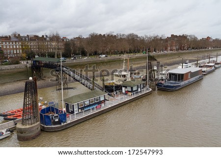 LONDON, UNITED KINGDOM - DECEMBER 28, 2011: Boats on river Thames during the low tide near Albert Bridge.  It is the longest river in England and the second longest in the United Kingdom.
