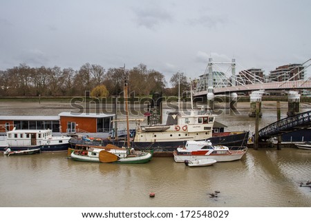 LONDON, UNITED KINGDOM - DECEMBER 28, 2011: Boats on river Thames during the low tide near Albert Bridge.  It is the longest river in England and the second longest in the United Kingdom.