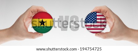 Man\'s hands holding styrofoam balls with Ghana and USA flag against the white background.