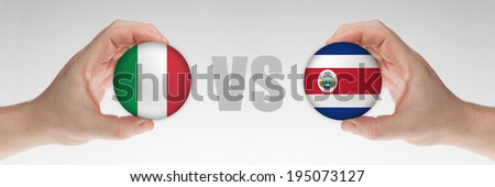 Man\'s hands holding styrofoam balls with Italian and Costa Rican flag against the white background.