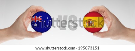 Man\'s hands holding styrofoam balls with Australian and Spanish flag against the white background.