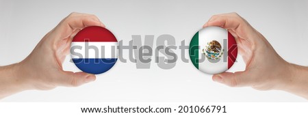 Man\'s hands holding styrofoam balls with Dutch and Mexican flag against the white background.