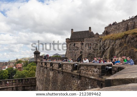 EDINBURGH, SCOTLAND: AUGUST 3, 2014: Tourists on the wall of Edinburgh Castle. Castle is most popular tourist attraction in Scotland.