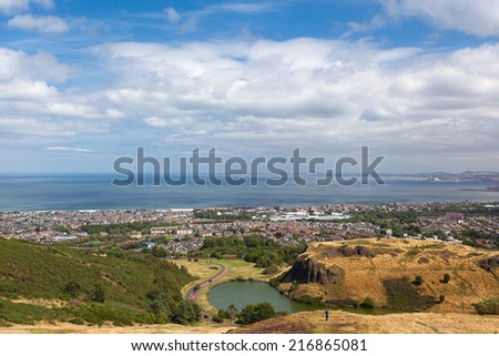 Panoramic view on St. Margaret\'s lake and city from hills in Holyrood Park. Park\'s highest point Arthur\'s seat is popular destination for hiking and enjoying nature.