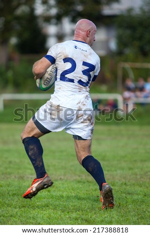 ZAGREB, CROATIA - SEPTEMBER 13, 2014: Croatian Rugby league - RC Zagreb Old Lions (white jersey) VS RC Sinj (dark blue jersey). Unidentified player running with the ball