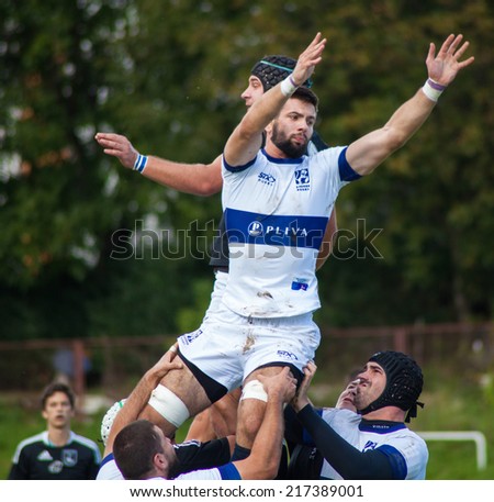 ZAGREB, CROATIA - SEPTEMBER 13, 2014: Croatian Rugby league - RC Zagreb Old Lions (white jersey) VS RC Sinj (dark blue jersey). Unidentified players catching the ball.