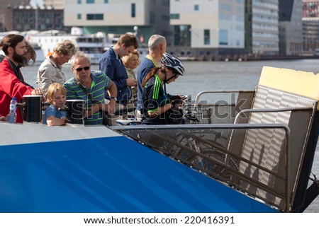AMSTERDAM - NETHERLANDS: AUGUST 13, 2014: People at fairy  that is connecting The Eye film Museum with Central station.
