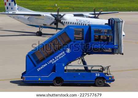 ZAGREB, CROATIA - APRIL 28, 2013: Passenger boarding stairs truck on Pleso airport runway.