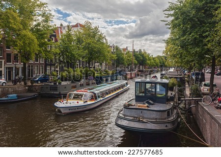 AMSTERDAM - NETHERLANDS: AUGUST 11, 2014: Tourist city sightseeing boat cruising in the canal.