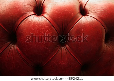 Closeup detail of red vintage chesterfield leather couch.