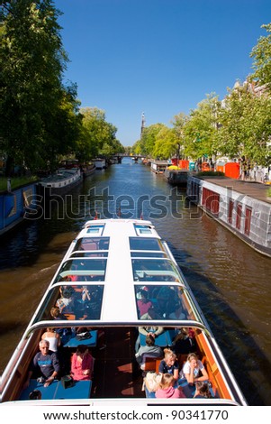 AMSTERDAM, NETHERLANDS - AUG 11: Tourist boat cruises on canal in Amsterdam on August 11, 2008.  Almost 20 percent of all canal cruise boats are now electrically powered