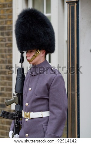 LONDON, ENGLAND - DEC 25: Grenadier guard wearing winter coat in front of the Clarence house on December 25, 2011 in London, England. Clarence house used to be home to Queen Elizabeth for 50 years