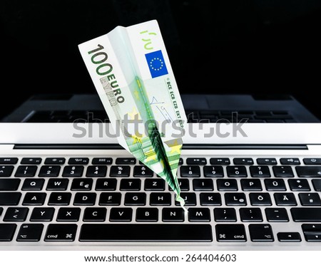 Crashed Euro paper airplane on computer keyboard (Euro crisis)