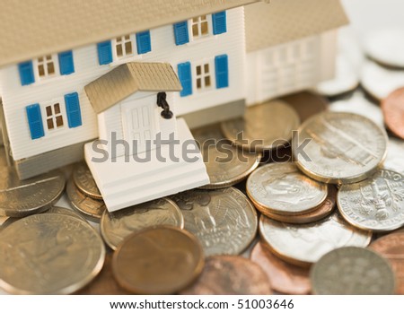 Tiny house resting on pile of american change
