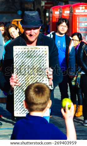 EDINBURGH, SCOTLAND -  11 APRIL, 2015: Street Artist performs with a bed of nails on the Royal Mile, Edinburgh