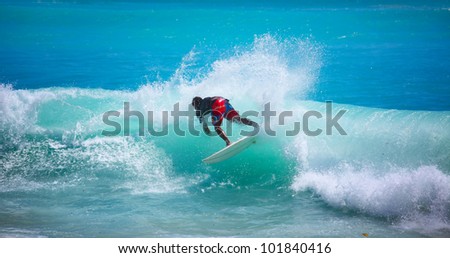 Young man surfing in tropical sea with blue water