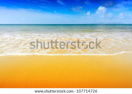 Blue tropical sea with summer sky and clouds on a horizon and perfect yellow sandy beach