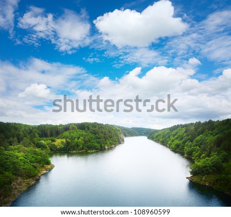 Wide river with green coasts and sky with clouds