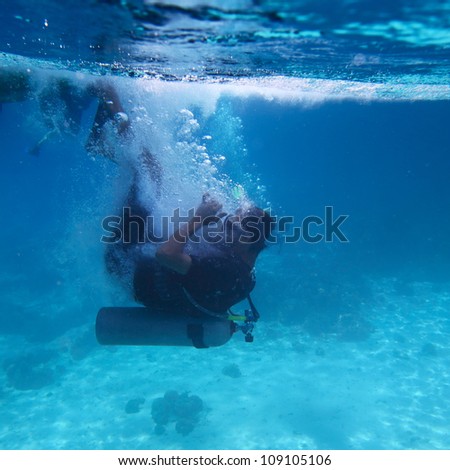 Underwater shoot of a diver doing back flip from a boat