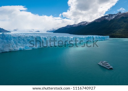 Front part of the Perito Moreno Glacier located in the Southern Patagonian Ice Field and touristic, day trip boat on the turquoise Lago Argentino. Argentina
