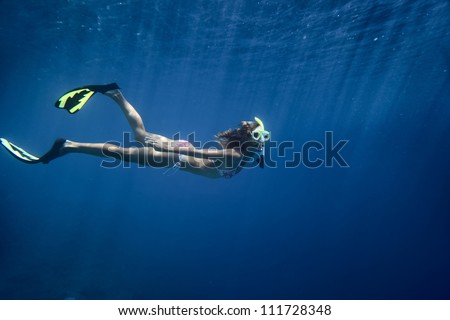 Underwater shoot of a young woman fining in a depth on a breath hold