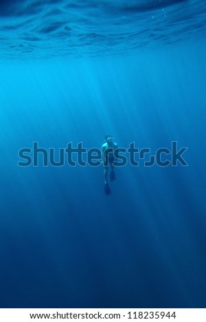 Underwater shoot of a young athlete fining from a depth to surface on a breath hold