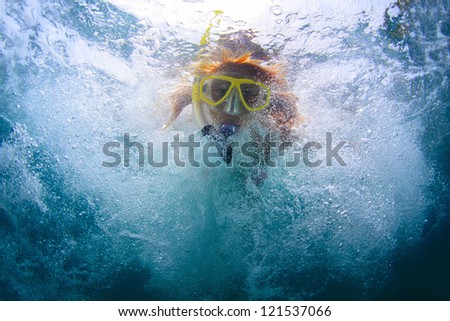 Close up underwater portrait of a woman in mask making bubbles