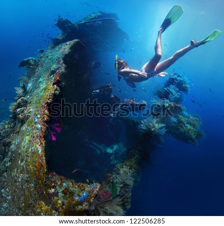 Underwater shoot of a woman exploring USAT Liberty wreck on a breath hold. Tulamben, Bali island, Indonesia