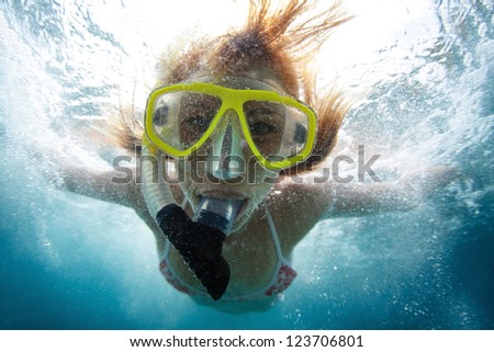Close up underwater portrait of a woman making skin dive with a lot of bubbles on face