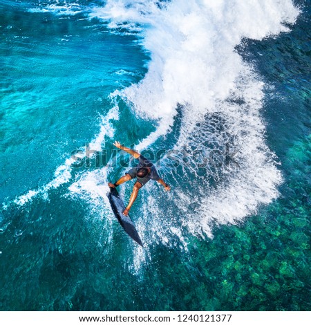 Aerial top down view of the surfer riding furious ocean wave. Makaha surf spot, Oahu, Hawaii