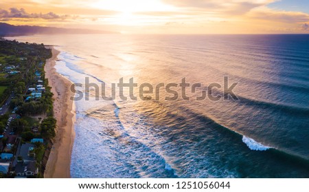Aerial view of the North Shore of Oahu at sunset. Area of Banzai Pipeline surf spot (breaking wave on the foreground at the right is Pipeline). Hawaii, USA