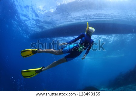 Underwater shoot of a young lady snorkeling and diving on a breath hold in a clear tropical sea