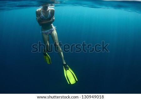 Young lady getting cold in a tropical sea and embracing herself during snorkeling. Horripelation on a skin!