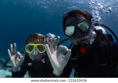 Scuba divers underwater showing ok signal