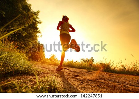 Young Lady Running On A Rural Road During Sunset