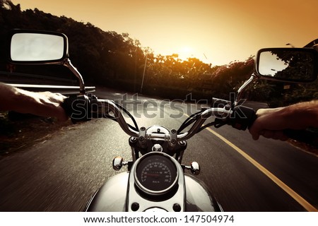 Driver Riding Motorcycle On An Asphalt Road Through Forest