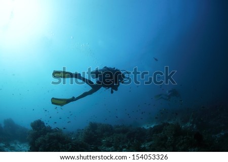 Scuba diver finning underwater and exploring dive spot