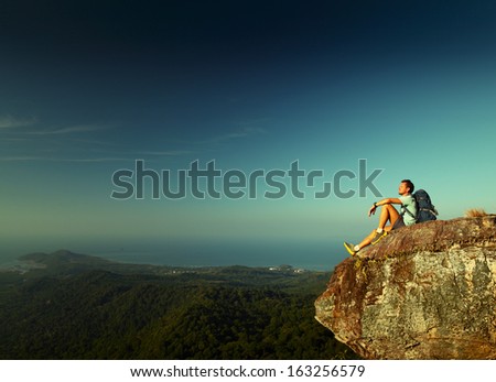 Male Hiker With Backpack Relaxing On Top Of A Mountain