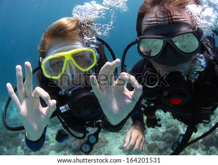 Scuba divers showing OK signal underwater