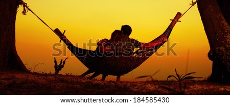 Couple relaxing in the hammock on a tropical beach