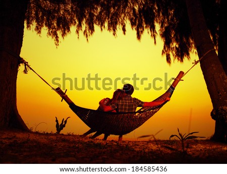 Couple relaxing in a hammock on the tropical beach